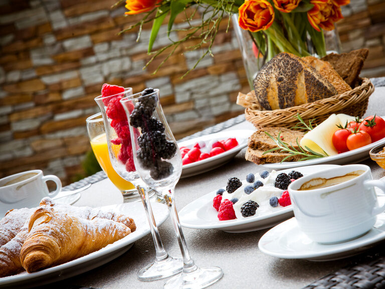 Ein Tisch ist reichlich mit frühstücks-Speisen gedeckt.