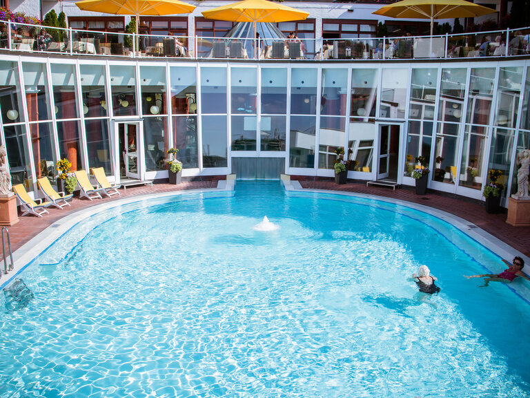 An einem warmen Sommertag schwimmen Gäste im Pool.